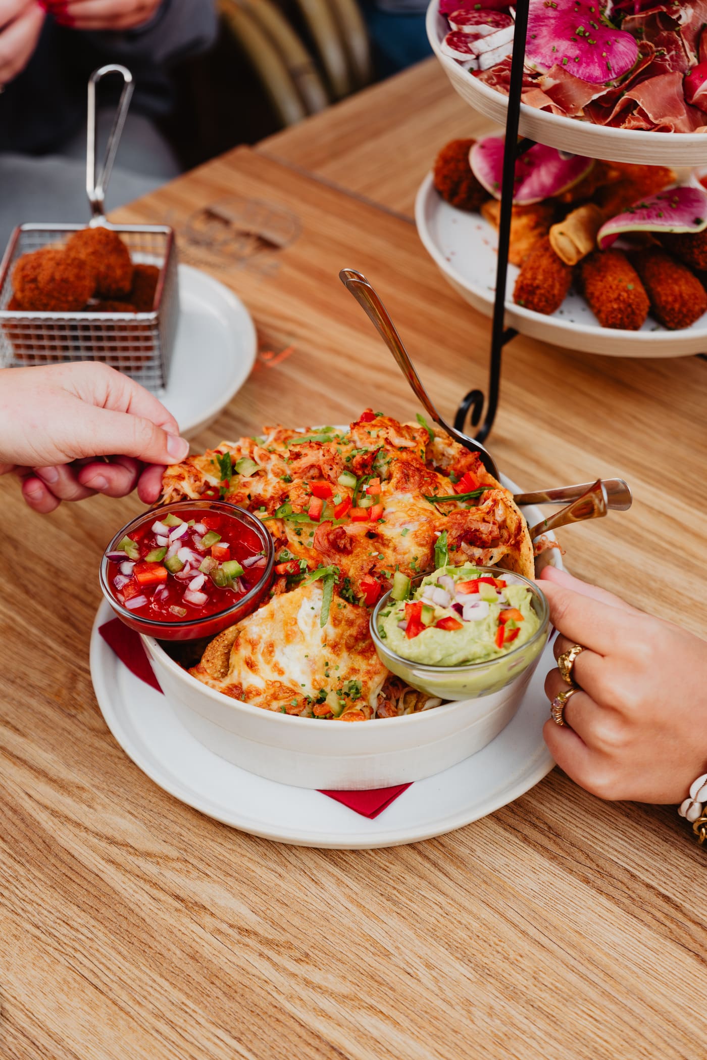 Nacho's met salsa en guacamole, gedeeld met handen